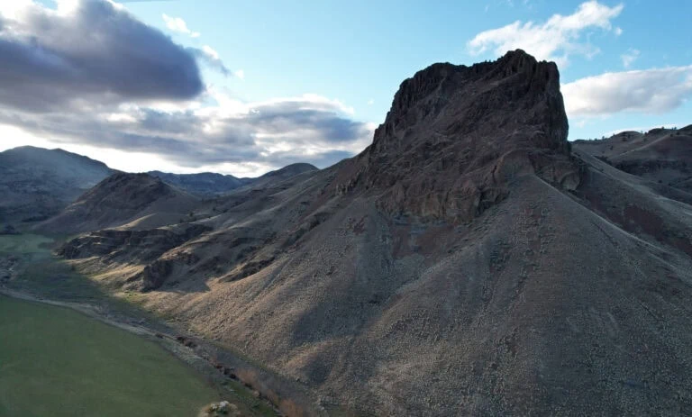 Majestic mountain landscape with rugged peaks and a partly cloudy sky.
